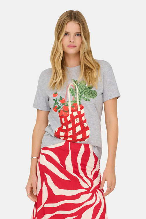 T-shirt gris chiné de ONLY®, avec un imprimé sac de marché rouge et blanc, porté avec une jupe à motifs zébrés rouges et beiges.