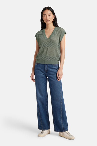 Débardeur vert en maille par ONLY®, porté avec un jean évasé et des baskets.
