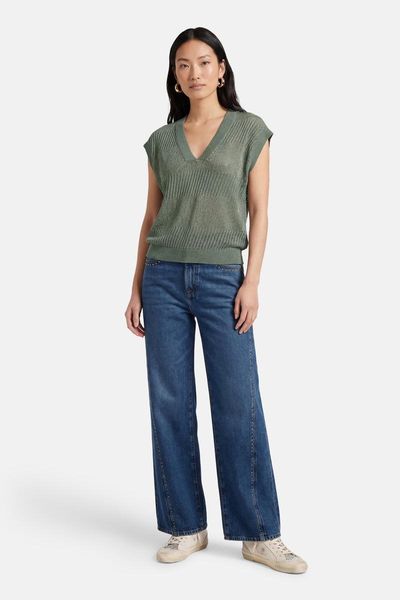 Débardeur vert en maille par ONLY®, porté avec un jean évasé et des baskets.
