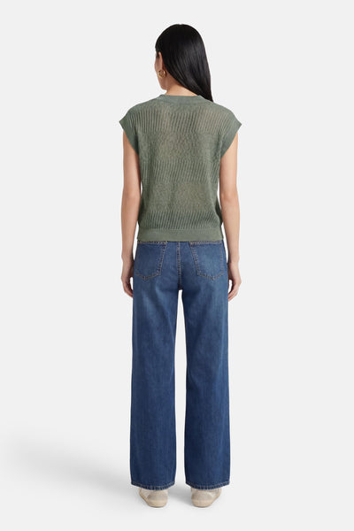 Débardeur vert ONLY® en maille ajourée, porté avec un jean taille haute ample et des baskets.