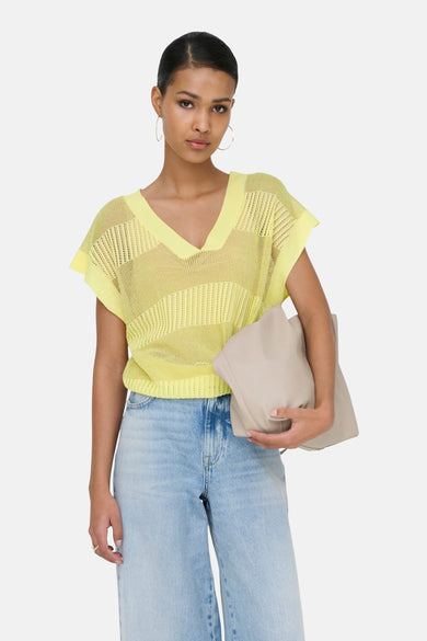 Gele kanten tanktop van ONLY, gedragen met een wijde blauwe jeans en een beige tas.