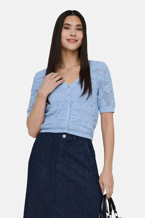 Gilet bleu en maille ajourée de ONLY, porté avec une jupe en jean foncée et un collier discret.
