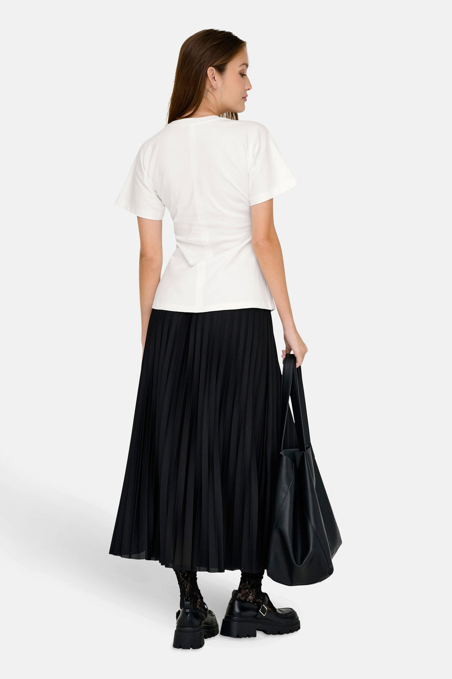 Top uni manches courtes blanc de ONLY®, porté avec une jupe plissée noire, un sac noir et des chaussures plateforme.