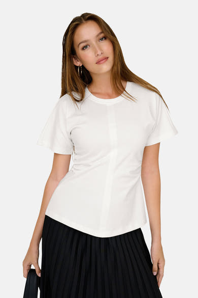 Top uni manches courtes blanc de ONLY®, porté avec une jupe plissée noire.
