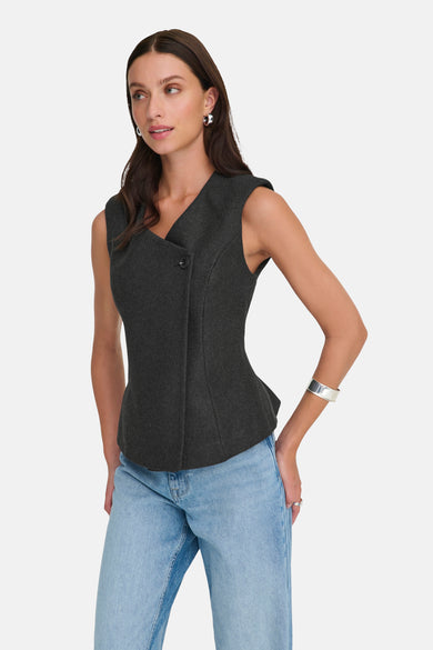 Blazer gris de ONLY, avec une coupe asymétrique et un bouton unique, porté avec un jean décontracté et des bijoux argentés.
