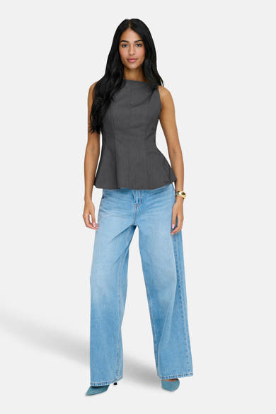 Grijze blouse van ONLY, gedragen met een wijde blauwe jeans en bijpassende blauwe schoenen