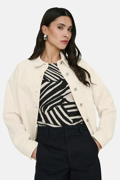 Veste courte écru de JDY avec fermeture boutonnée et poches, portée sur un haut imprimé zèbre.