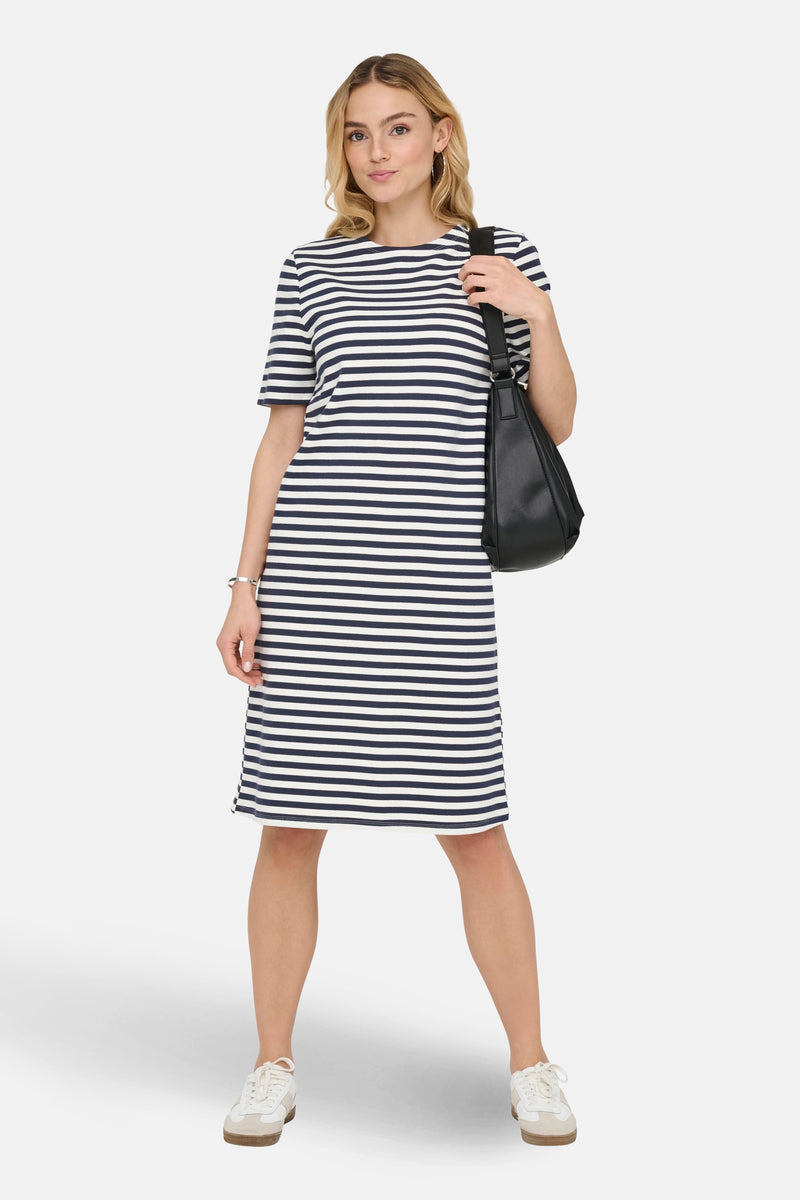 Robe à rayures bleues et blanches par JDY, portée avec un sac noir et des baskets blanches.
