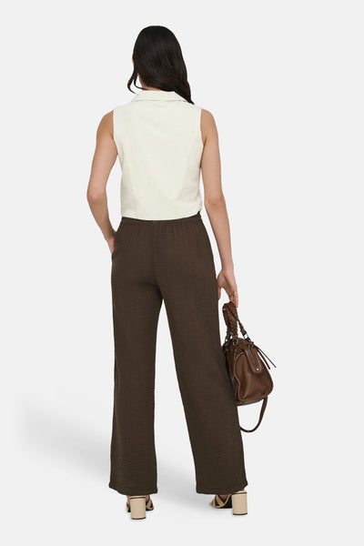 Beige blazer van JDY, mouwloos, gedragen met een losse bruine broek en een leren handtas.