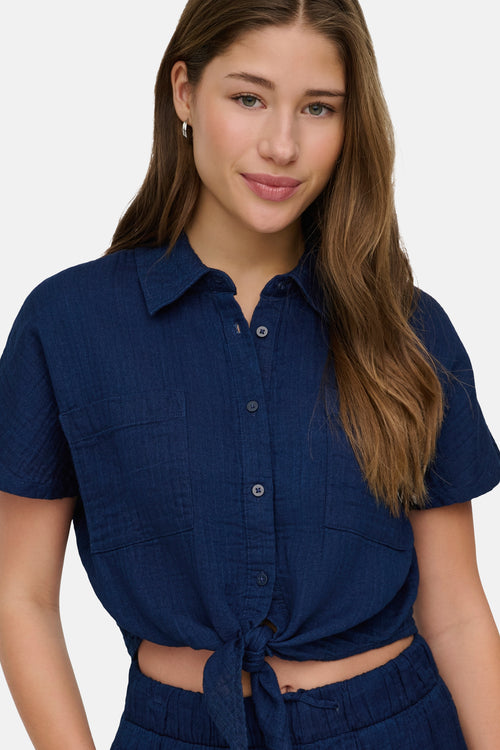 Chemisier bleu à manches courtes de ONLY, noué à la taille avec poches plaquées.