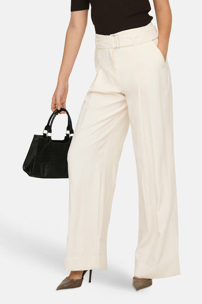 Pantalon beige large de ONLY®, taille haute, ceinturé avec boucle argentée, porté avec un haut et un sac noirs.
