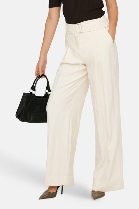 Pantalon beige large de ONLY®, taille haute, ceinturé avec boucle argentée, porté avec un haut et un sac noirs.