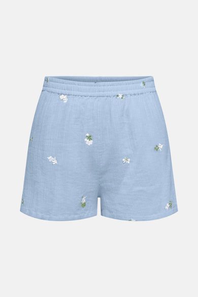 Short bleu en lin de JDY, agrémenté de délicates broderies florales blanches et vertes.
