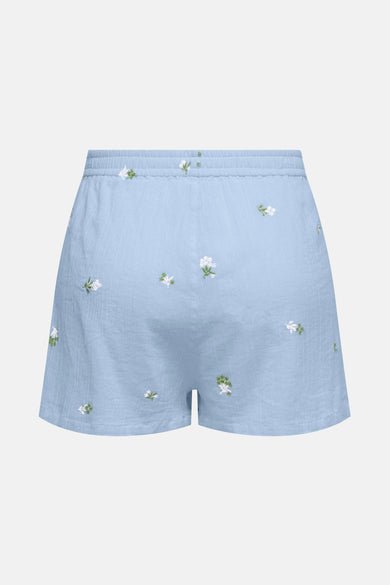 Short bleu de JDY avec broderies florales blanches et vertes, détail de texture gaufrée.
