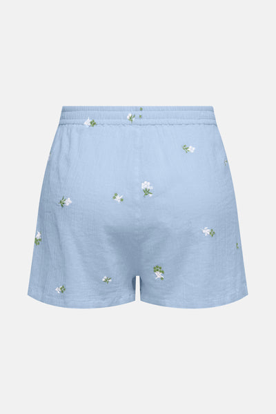 Short bleu de JDY avec broderies florales blanches et vertes, détail de texture gaufrée.
