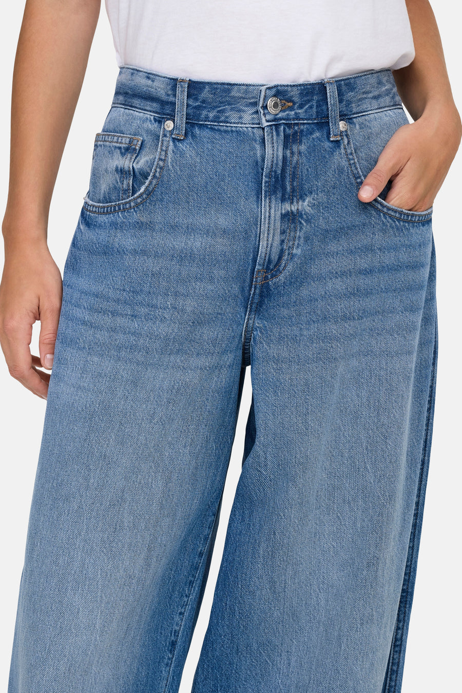 Jean en denim bleu clair par ONLY, avec une poche avant et une main dans une autre poche.
