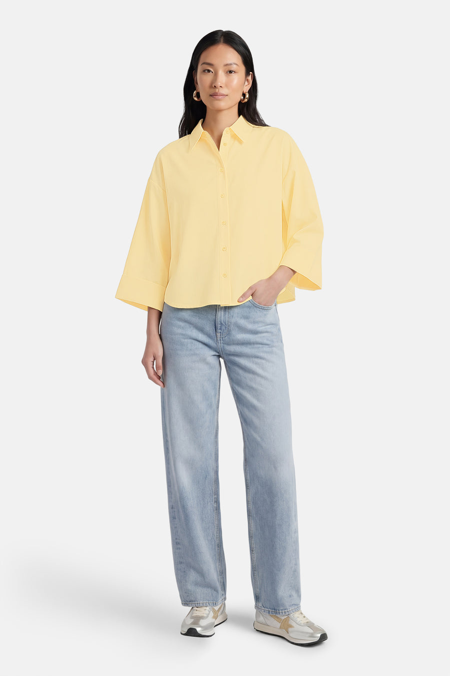Chemise jaune à manches longues de ONLY, portée avec un jean bleu et des baskets argentées.