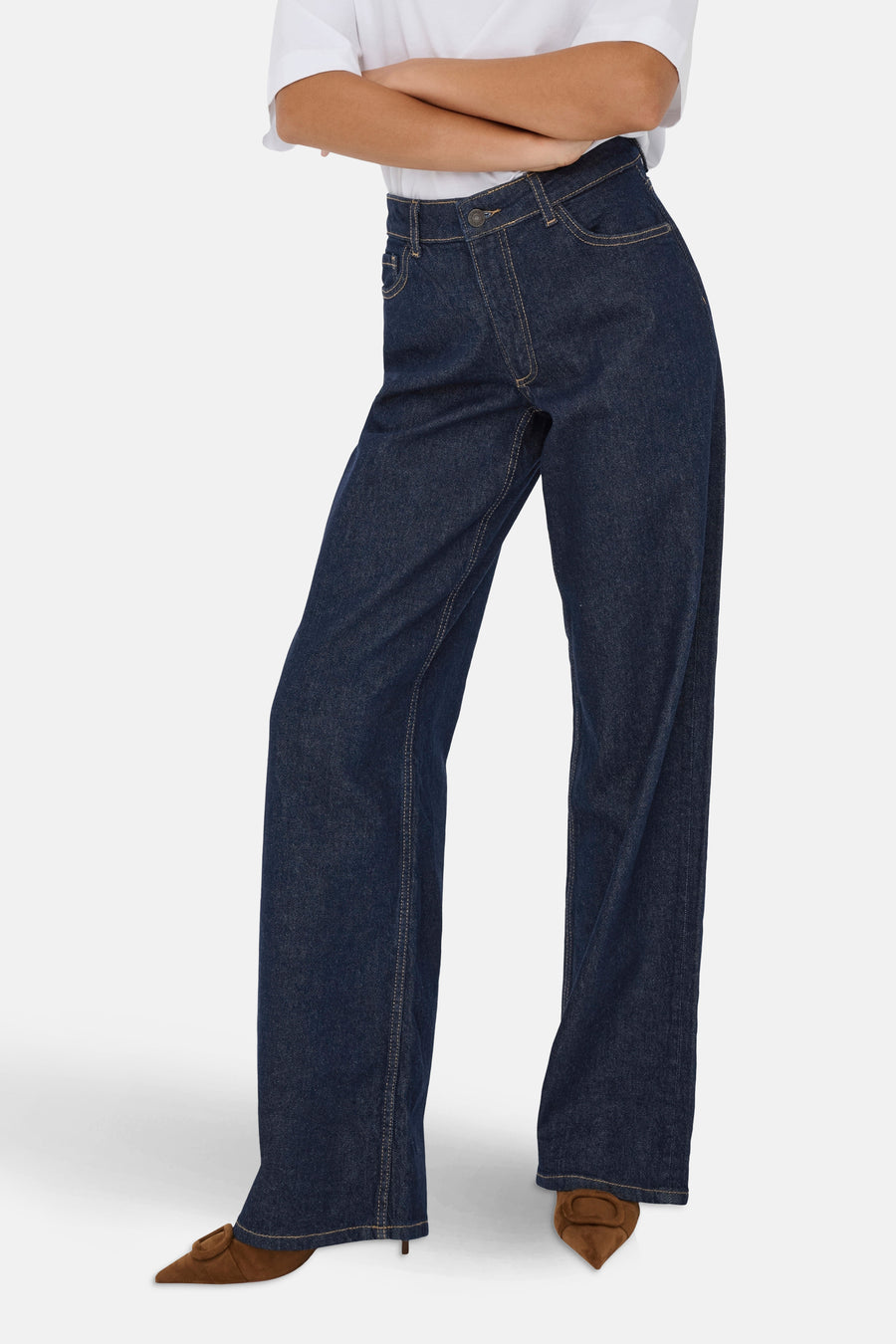 Wijde jeans in donkerblauw denim van JDY, gedragen met een wit T-shirt en bruine pumps.