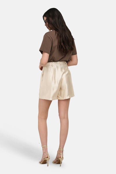 Gouden short van ONLY®, getextureerd, gedragen met een bruin T-shirt en beige sandalen met bandjes, achterzicht.