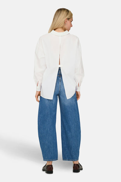 Wit overhemd met lange mouwen van ONLY, met opening aan de achterkant en gedragen met een wijde jeans.