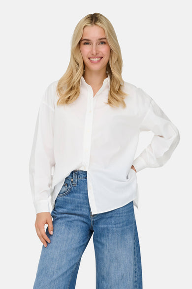 Wit overhemd met lange mouwen van ONLY, gedragen met een blauwe high-waist jeans.