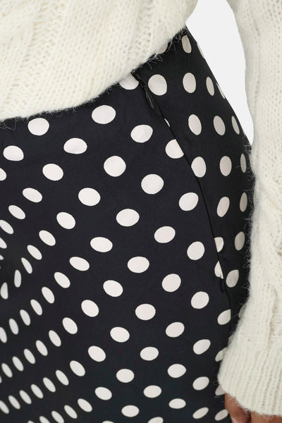 Jupe noire à pois blancs de ONLY, avec fermeture éclair latérale et texture tricotée crème visible.