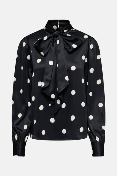 Chemisier noir à manches longues de ONLY, avec motif à pois blancs et nœud décoratif.
