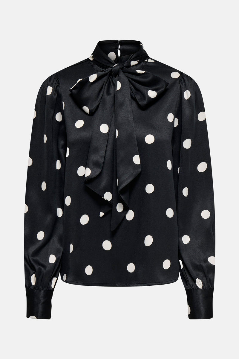 Chemisier noir à manches longues de ONLY, avec motif à pois blancs et nœud décoratif.
