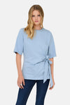 T-shirt bleu à manches courtes de ONLY, avec un nœud décoratif sur le côté et porté avec un jean.
