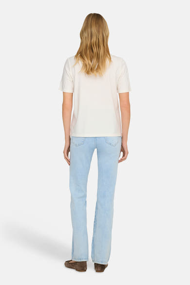 T-shirt blanc à manches courtes de ONLY, porté avec un jean bleu clair et des ballerines marron.