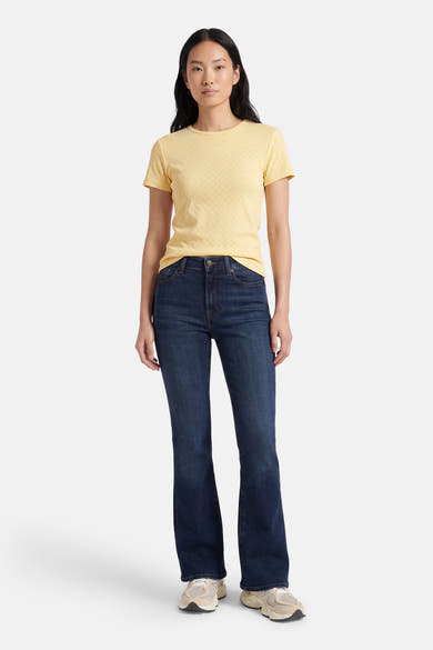 T-shirt jaune à manches courtes de ONLY®, avec un motif texturé, porté avec un jean bleu et des baskets.