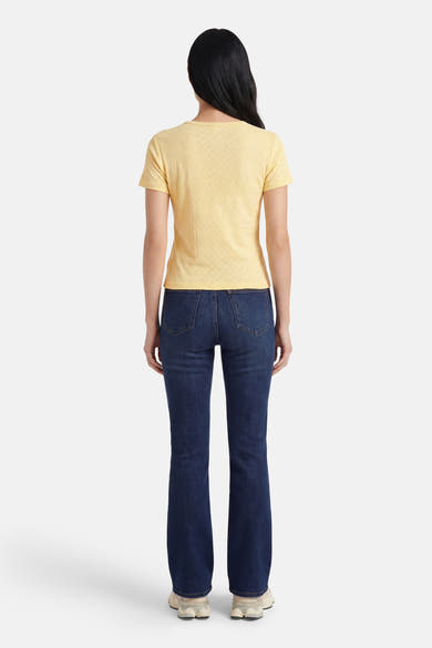 T-shirt jaune à manches courtes de ONLY, avec un motif texturé subtil, porté avec un jean bleu.
