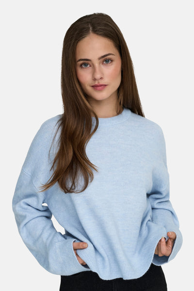 Ronde hals trui blauw van ONLY, gedragen door een model met lang bruin haar.