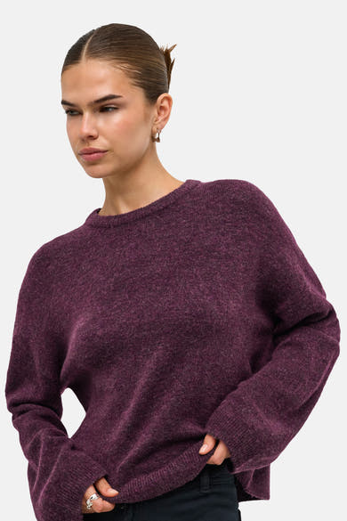 Mauve wine crewneck sweater with soft marled texture, oversized fit, and ribbed cuffs, worn by model in side view