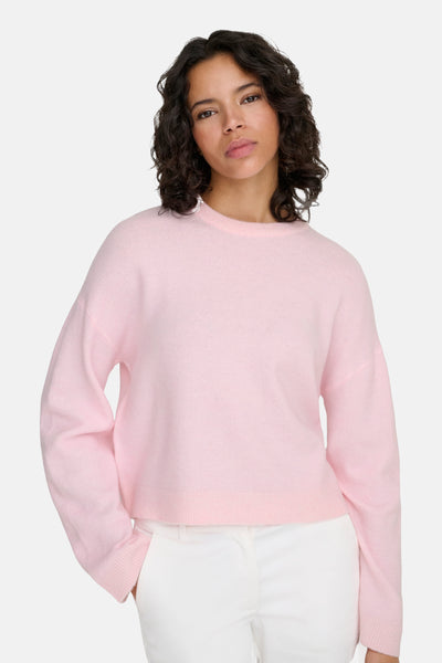 Ronde hals roze trui van ONLY® met een zachte textuur, gedragen met een witte broek.