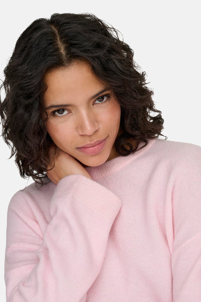 Ronde hals roze trui van ONLY, gedragen door een vrouw met een lichte effen achtergrond.