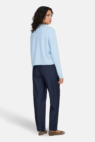 Cardigan bleu ONLY® avec une texture douce, porté avec un pantalon large en denim et des ballerines marron.