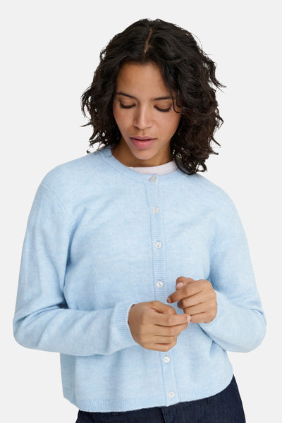 Blauwe gebreide cardigan van ONLY met een zachte textuur, knoopsluiting en lange mouwen, gedragen met een wit T-shirt.