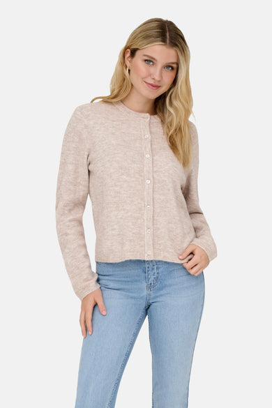 Cardigan beige de ONLY, avec des boutons blancs, porté avec un jean bleu clair.