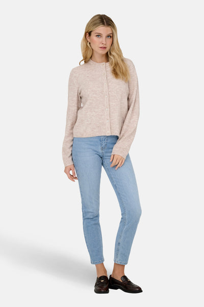 Cardigan beige de ONLY agrémenté de boutons, porté avec un jean bleu clair et des mocassins marron.
