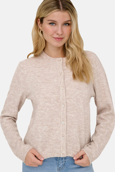 Beige cardigan van ONLY met een rij knopen, gedragen met een spijkerbroek.