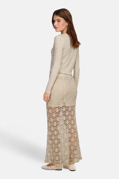 Crèmekleurige lange rok van ONLY® in bloemenkant, gedeeltelijk doorschijnend aan de onderkant, gedragen door een model.