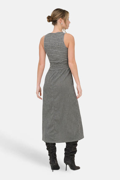 Robe noire de ONLY®, motif pied-de-poule, longueur midi, portée avec des bottes à talons hauts.