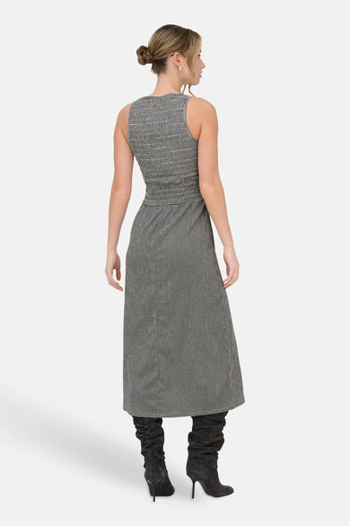 Robe noire de ONLY®, motif pied-de-poule, longueur midi, portée avec des bottes à talons hauts.