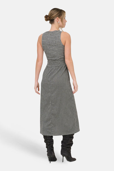 Robe noire de ONLY®, motif pied-de-poule, longueur midi, portée avec des bottes à talons hauts.