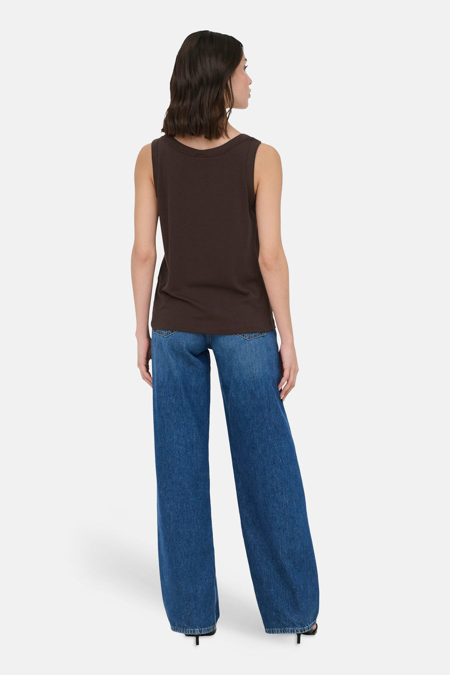 Bruin mouwloos topje van JDY, van achteren gezien op een model met een wijde jeans en hakken.