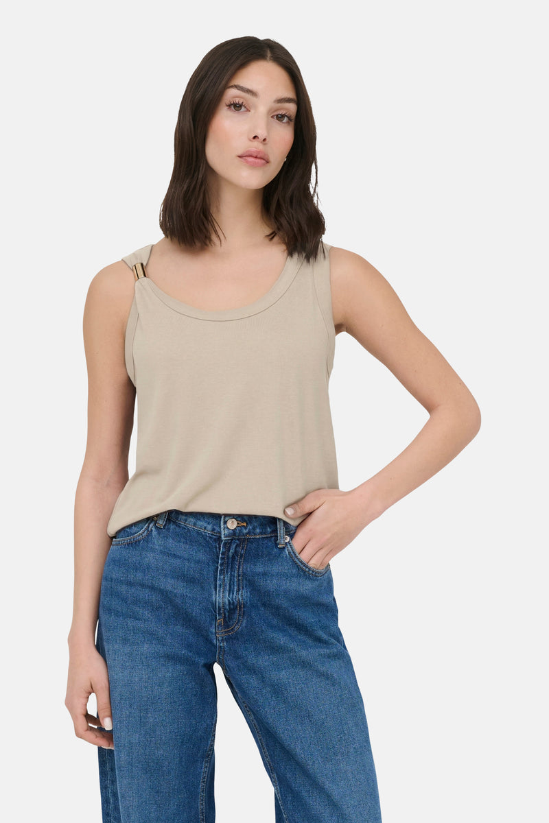 Top sans manches beige en jersey de JDY avec une boucle dorée sur l'épaule, porté avec un jean bleu.