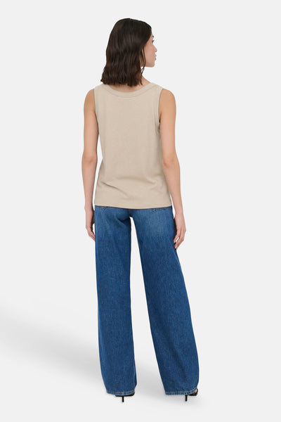 Top sans manches beige de JDY, vue de dos avec un jean large et des talons.