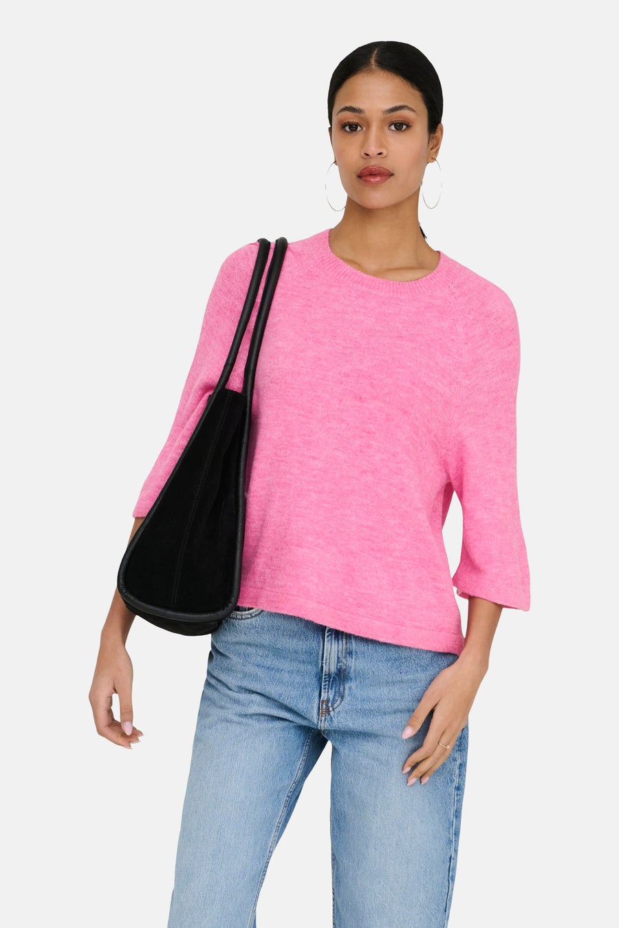 Roze rondehals trui van JDY, korte mouwen, gedragen met een wijde jeans en een zwarte tas.
