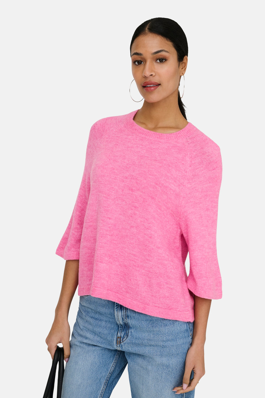Roze trui met ronde hals van JDY, gedragen met een blauwe spijkerbroek en oorringen.